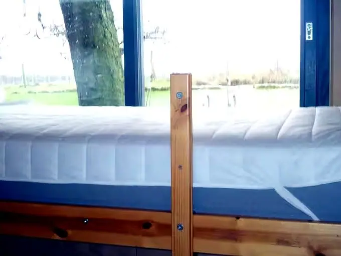 Stapelbed in het kleine kamertje met raam naar de tuin