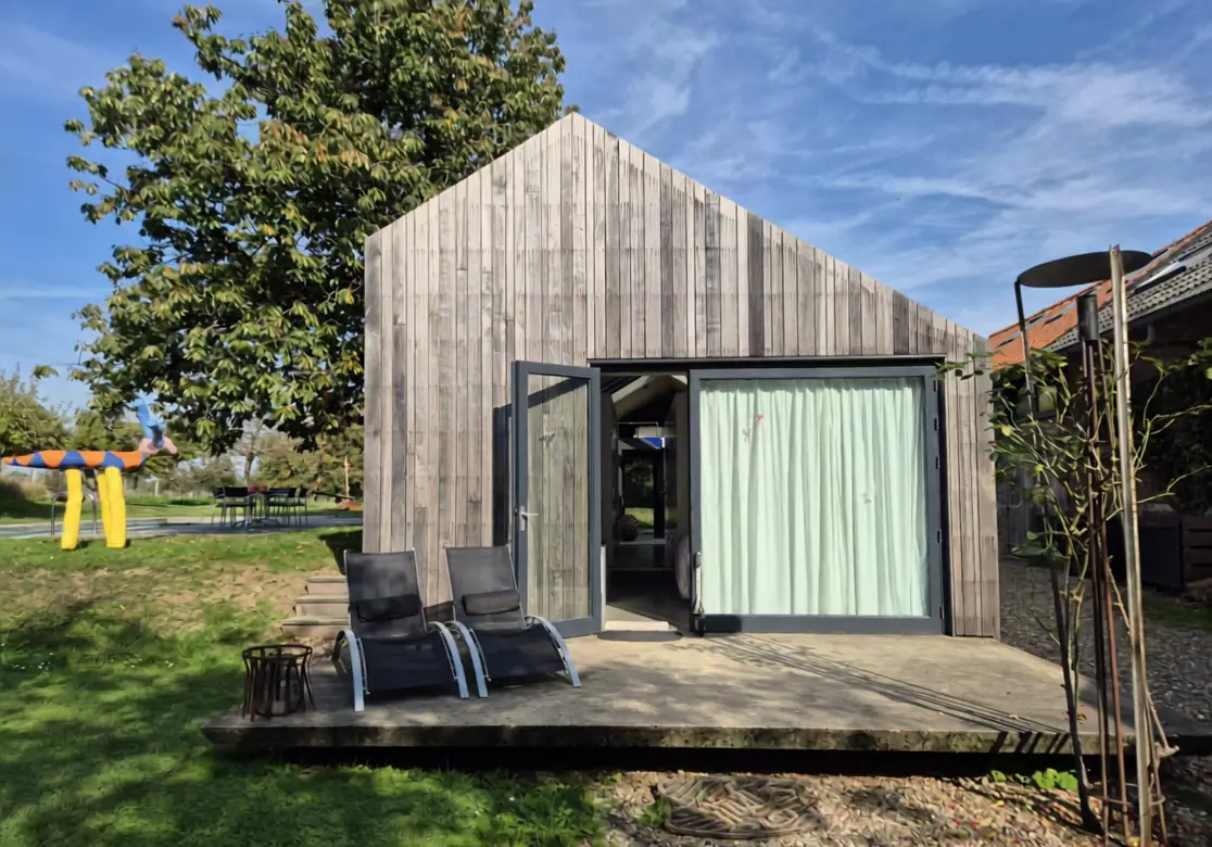 De houten voorgevel van het huis met open deur, het begin van de rondgang